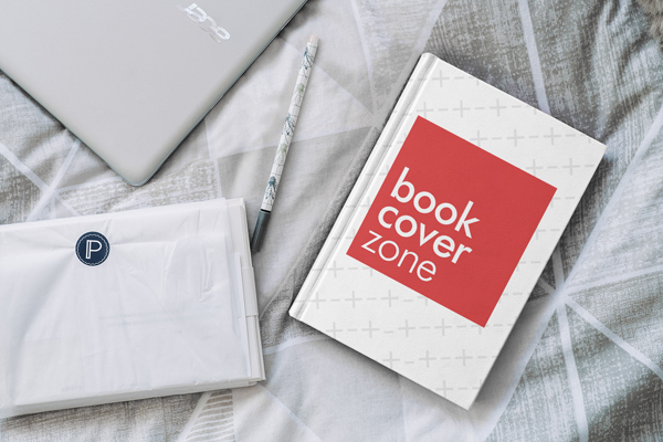 Hardcover Book on Bed with Laptop