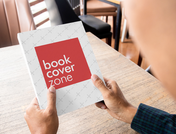 Paperback Book Mockup Held by a Man